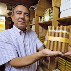 Abel Expósito Diaz, who runs the shop at the Partagás Cigar Factory, shows off a selection of Cohiba Siglo VI cigars.